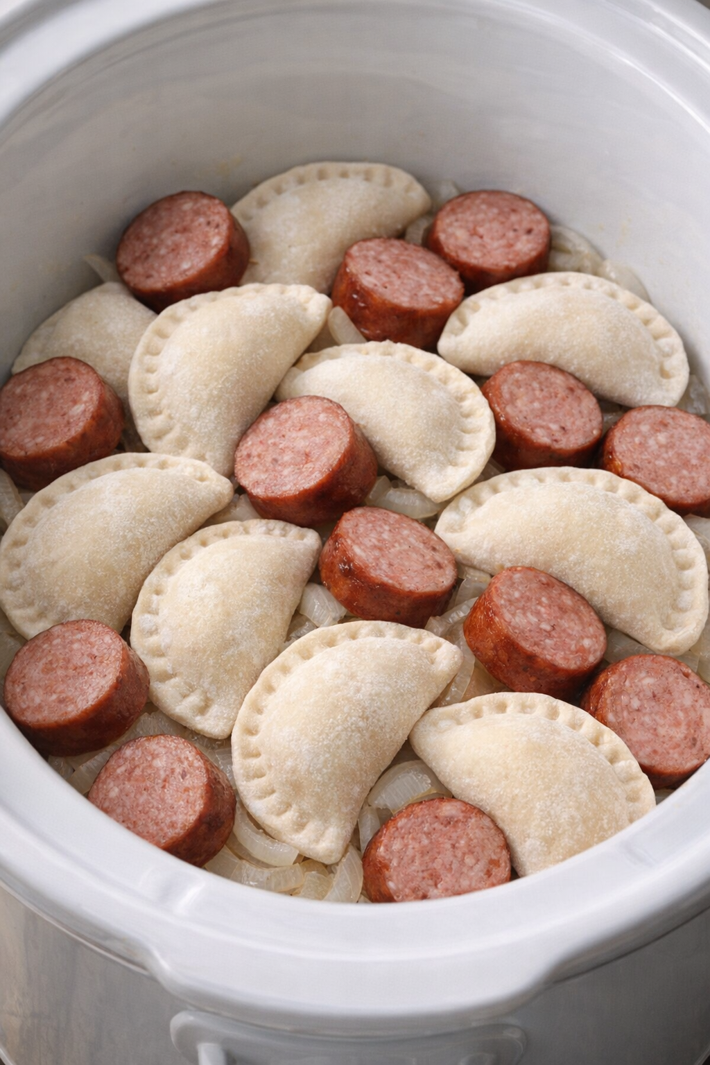 Uncooked pierogies and sausage in the slow cooker