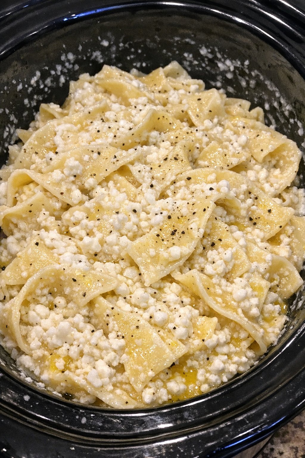 Slow cooker Amish cottage cheese noodles in a black slow cooker