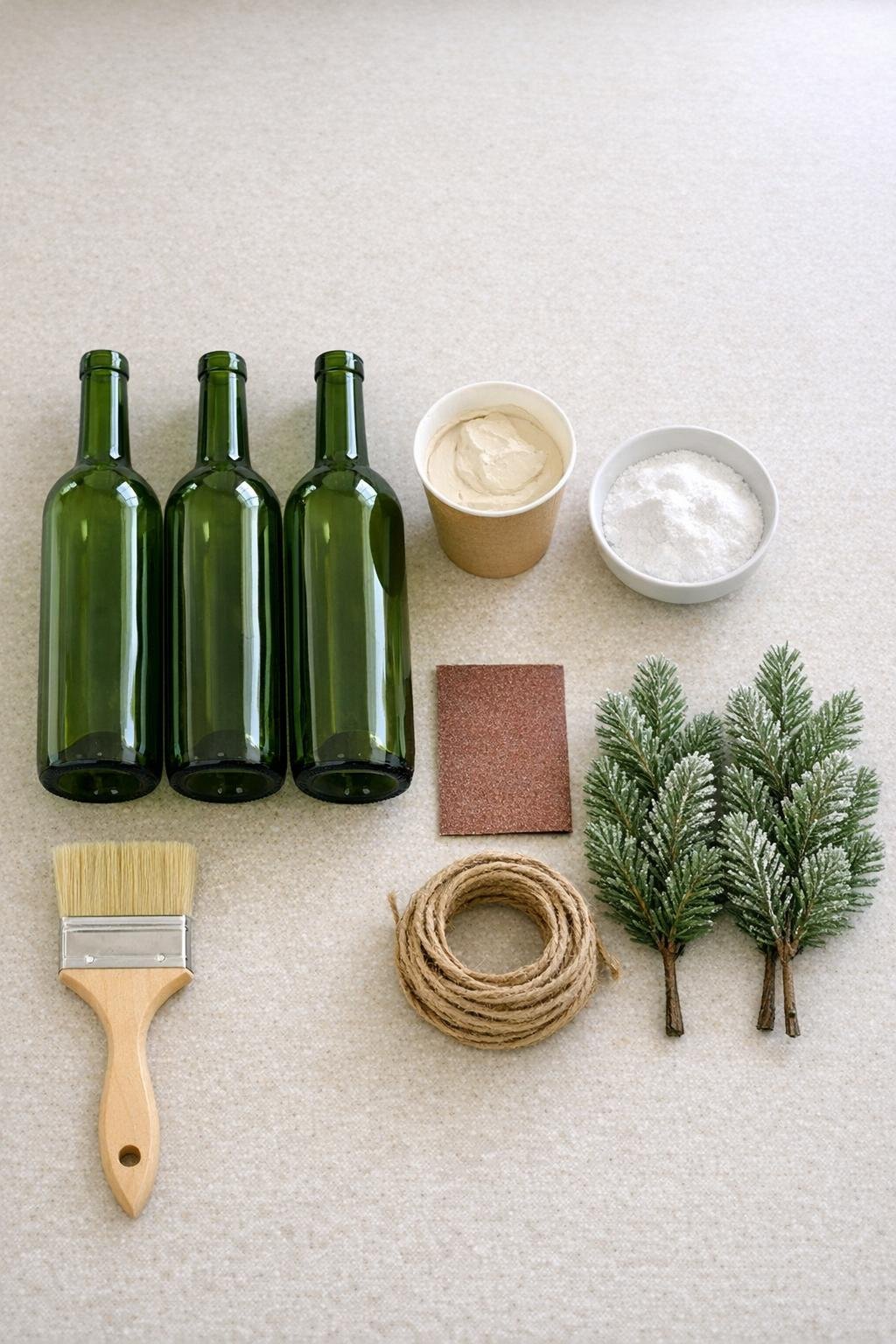 Materials for painted winter bottle vase project laid out on a counter