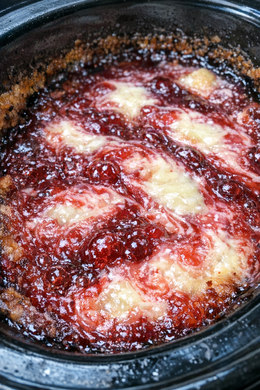 Ruby-red and white marbled gooey dessert in a slow cooker