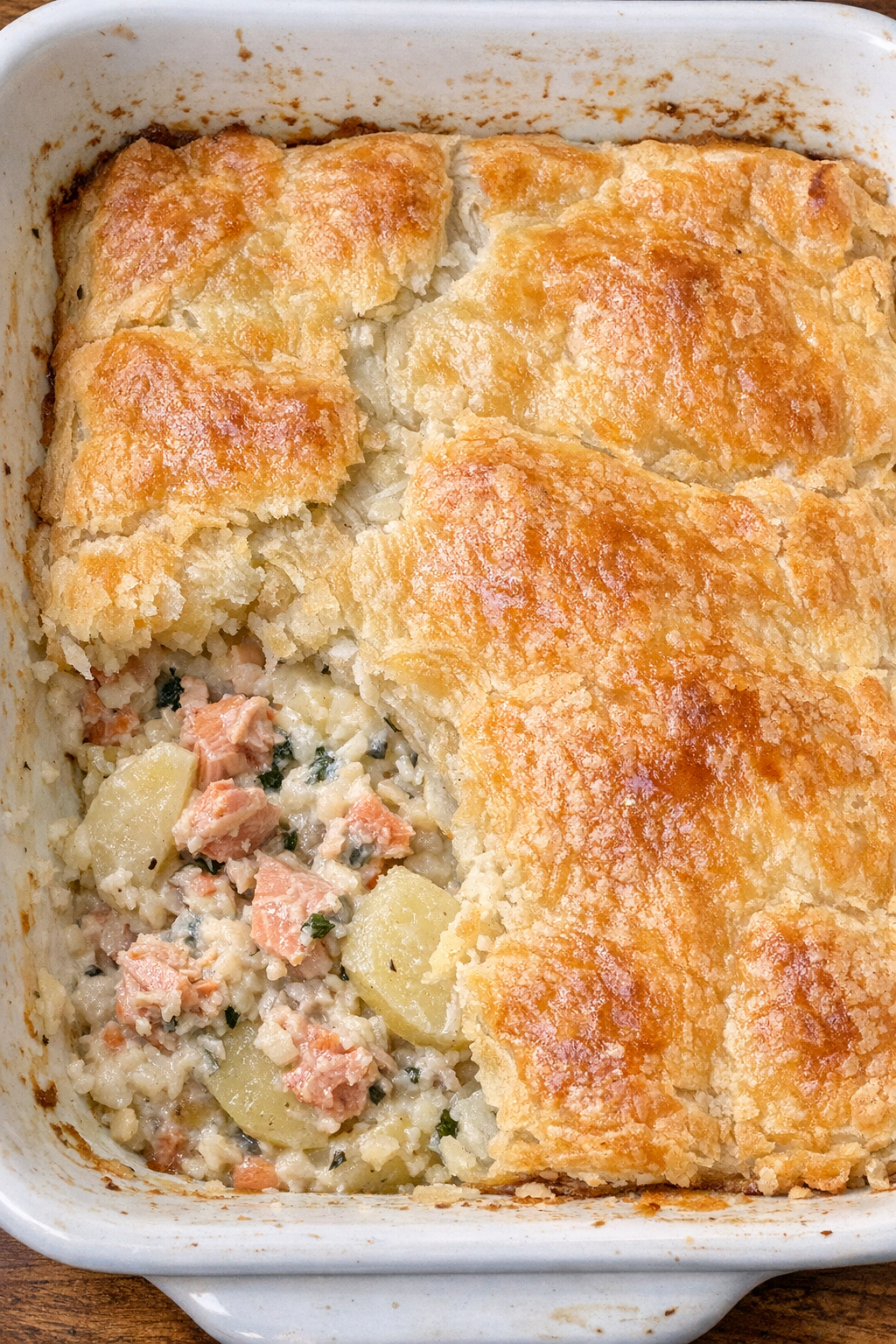 Flaky topped potato and salmon pie in a white casserole dish