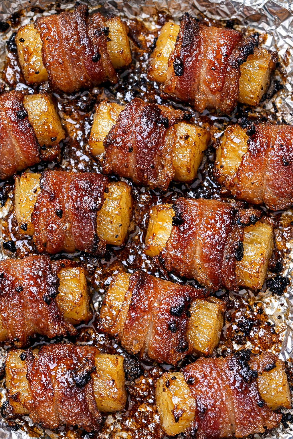 Southern 3-ingredient bacon wrapped pineapple on a foil-lined baking tray