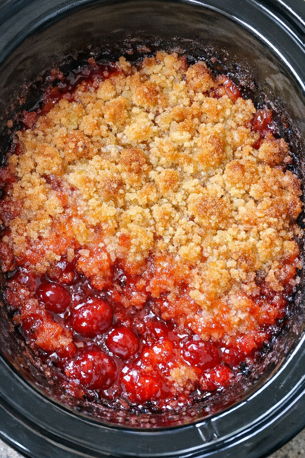 Slow cooker Shirley Temple dump cake in a black slow cooker
