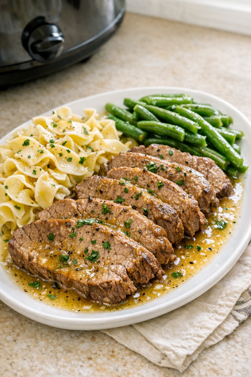 Plated slow cooker lemon beef with juices and herbs