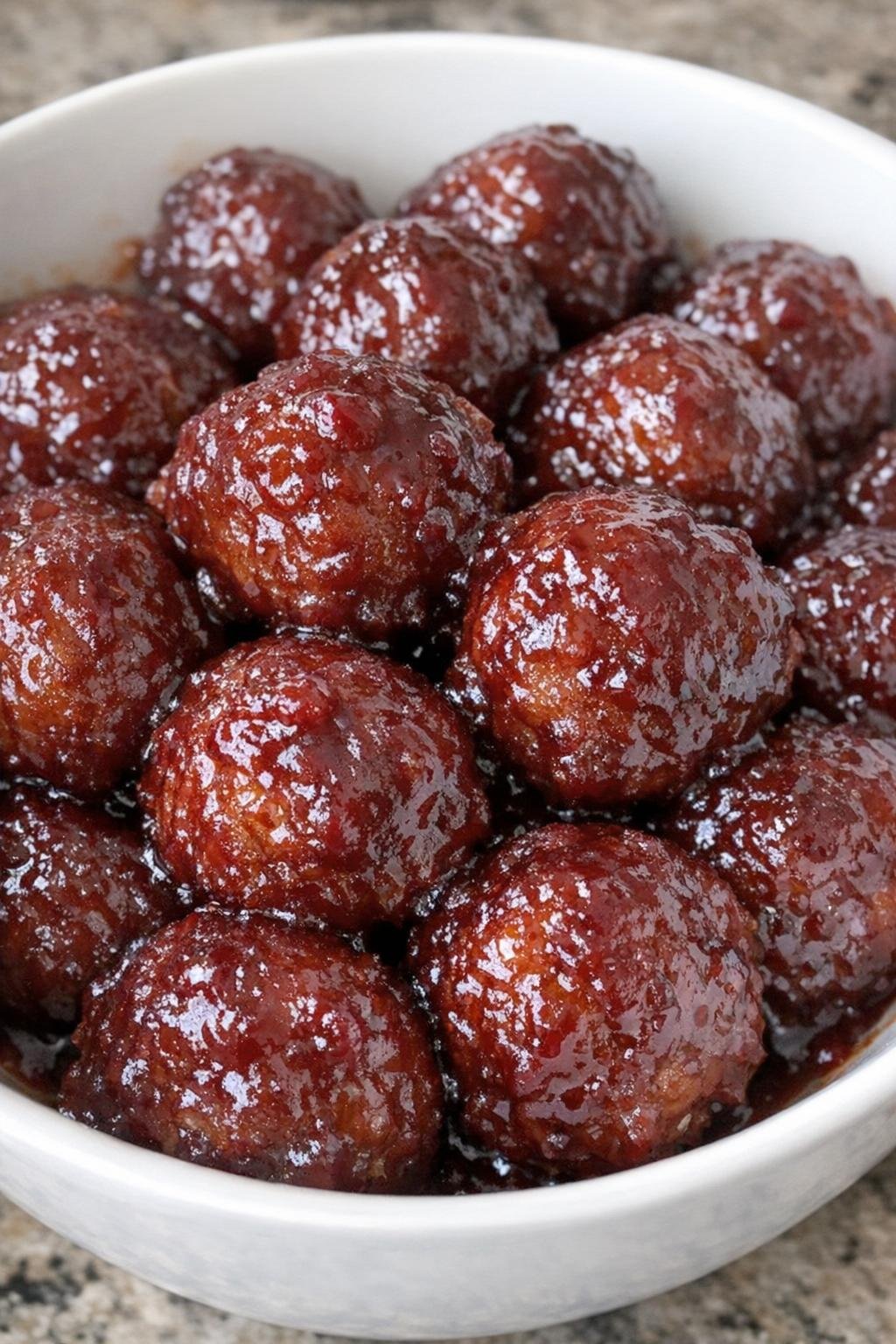 Cranberry glazed meatballs in a white serving bowl