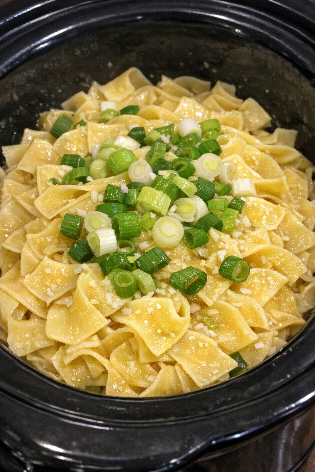 Slow cooker Amish scallion butter noodles in a black slow cooker