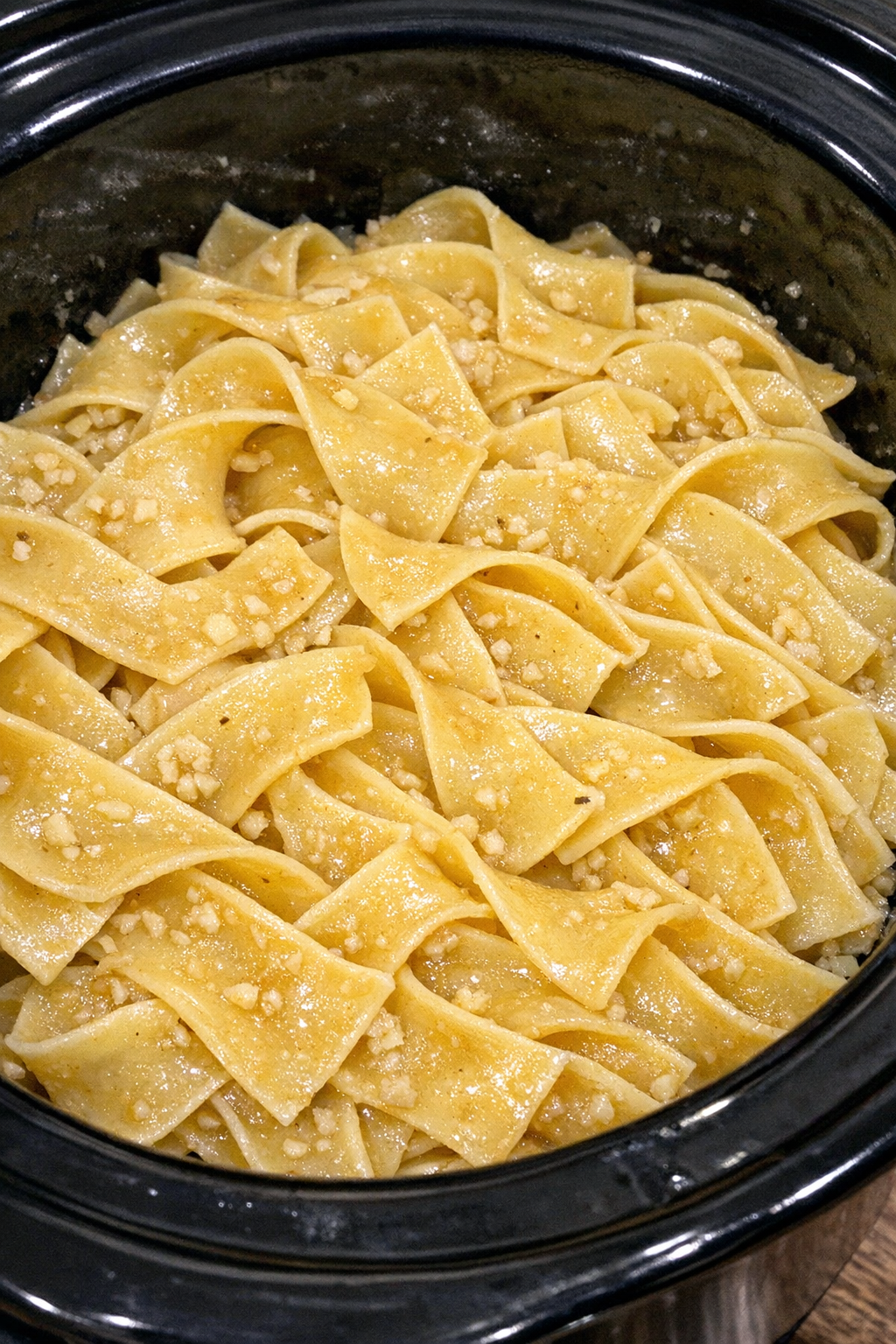 Slow cooker Amish garlic butter noodles in a black slow cooker
