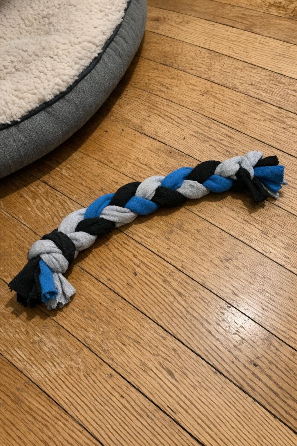A tightly braided dog tug toy made from three socks