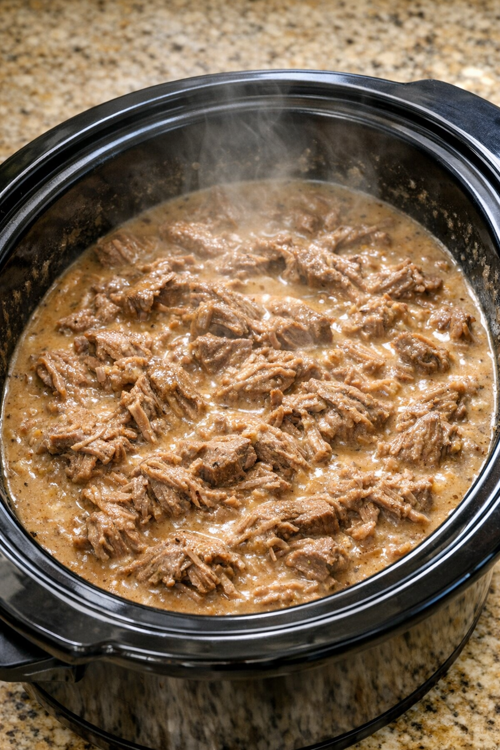 Tender cooked beef in creamy sauce inside the slow cooker