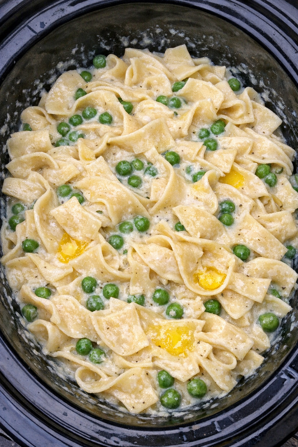 Slow cooker Amish creamed peas noodles in a black slow cooker