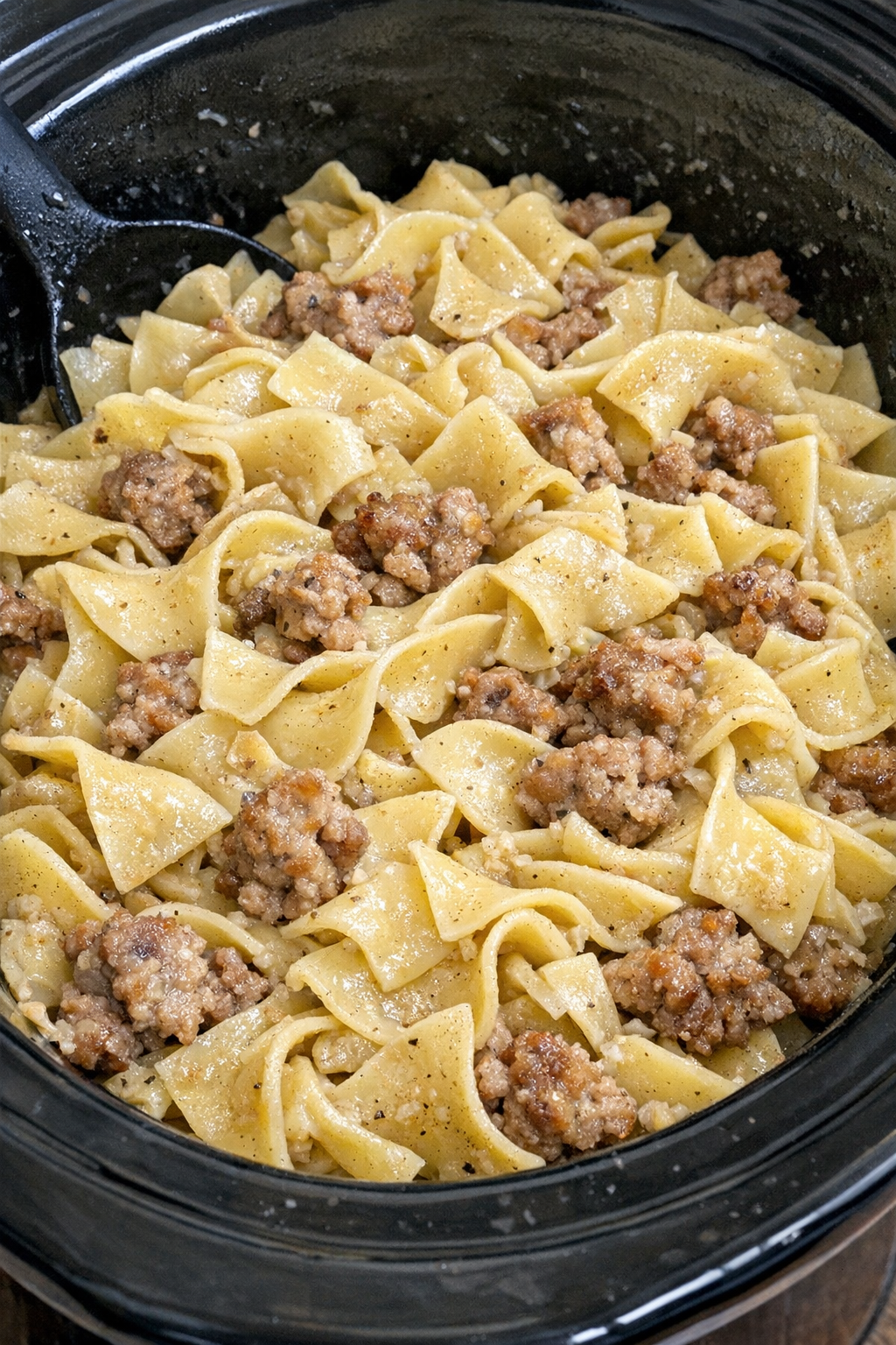 Slow cooker Amish sausage noodles in a black slow cooker