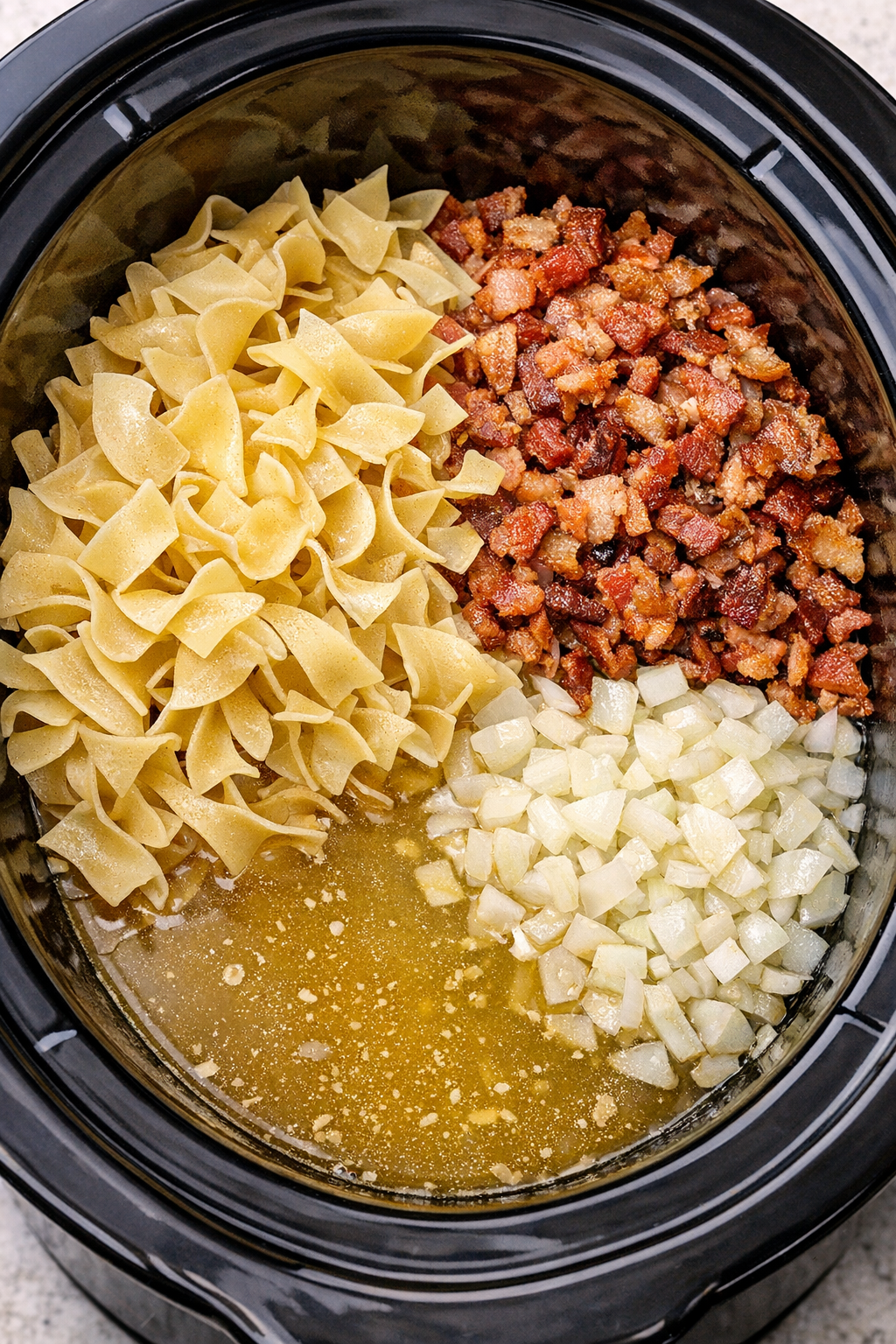 Egg noodles and broth being added to the slow cooker
