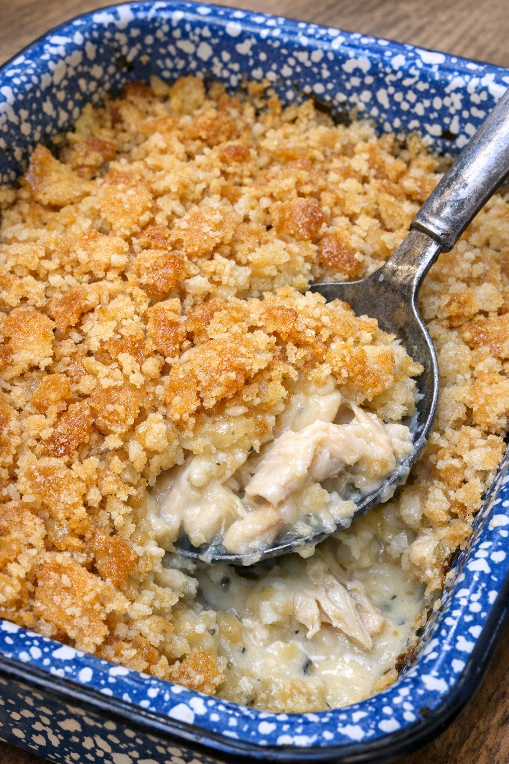 Crispy topped chicken casserole in a blue speckled enamel baking dish