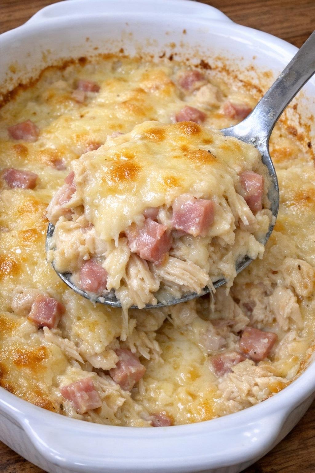 Golden bubbly chicken cordon bleu casserole in a white dish