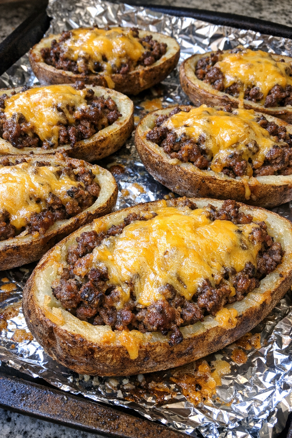 Oven baked beef potato skins on a foil-lined baking sheet