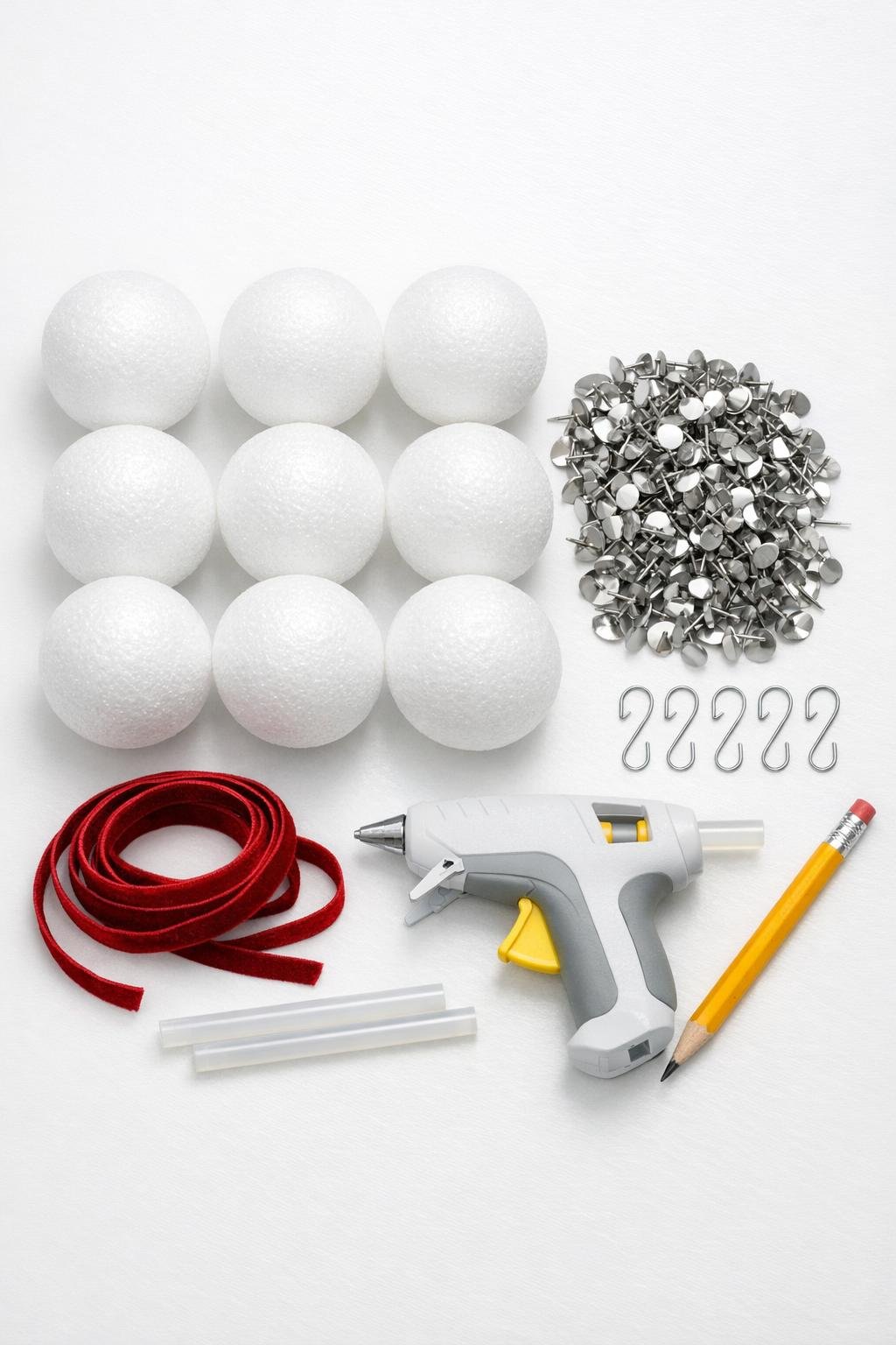 Materials laid out for silver thumbtack foam ball ornaments
