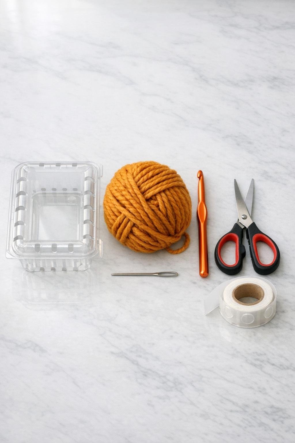 Materials for a crocheted berry box basket laid out on a counter
