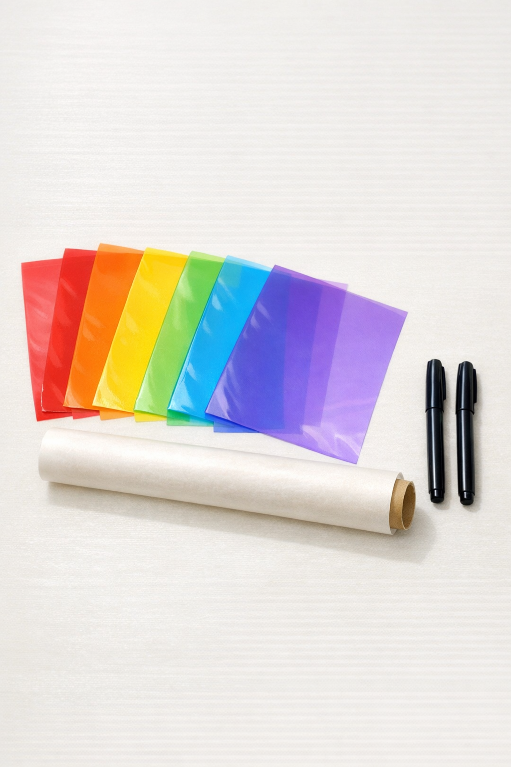 Plastic binder dividers, parchment paper, and black permanent markers laid out for the project
