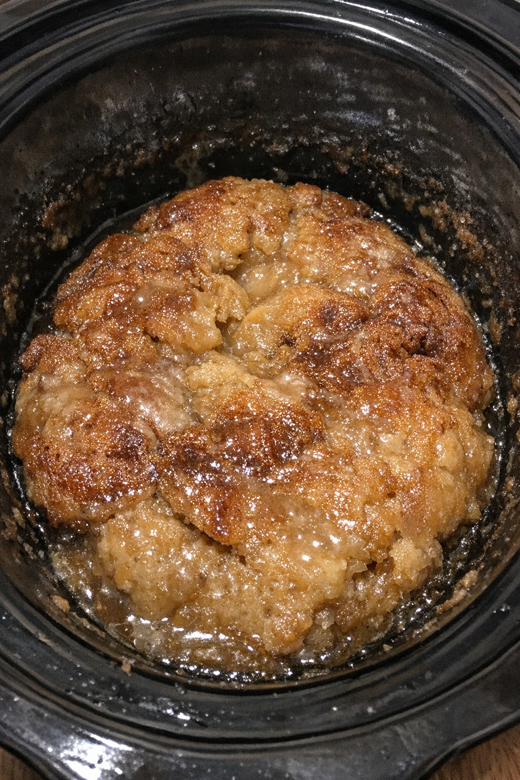 Slow cooker dessert with a dense fudgy beige mound and glossy glaze