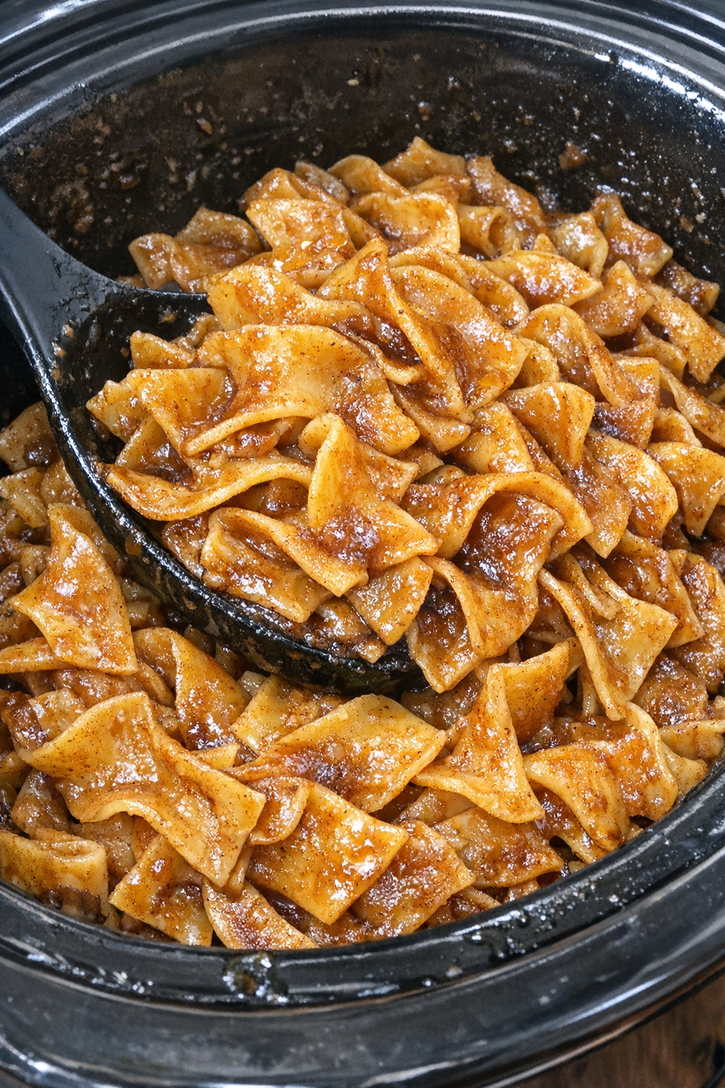 Slow cooker Amish apple butter noodles in a black slow cooker
