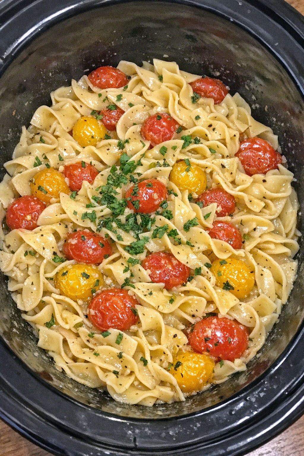 Slow cooker Amish cherry tomato noodles in a black slow cooker