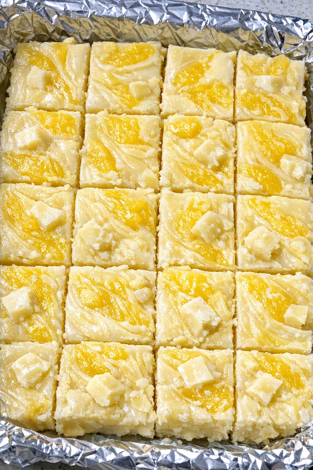Pineapple whip fudge in a foil-lined baking sheet