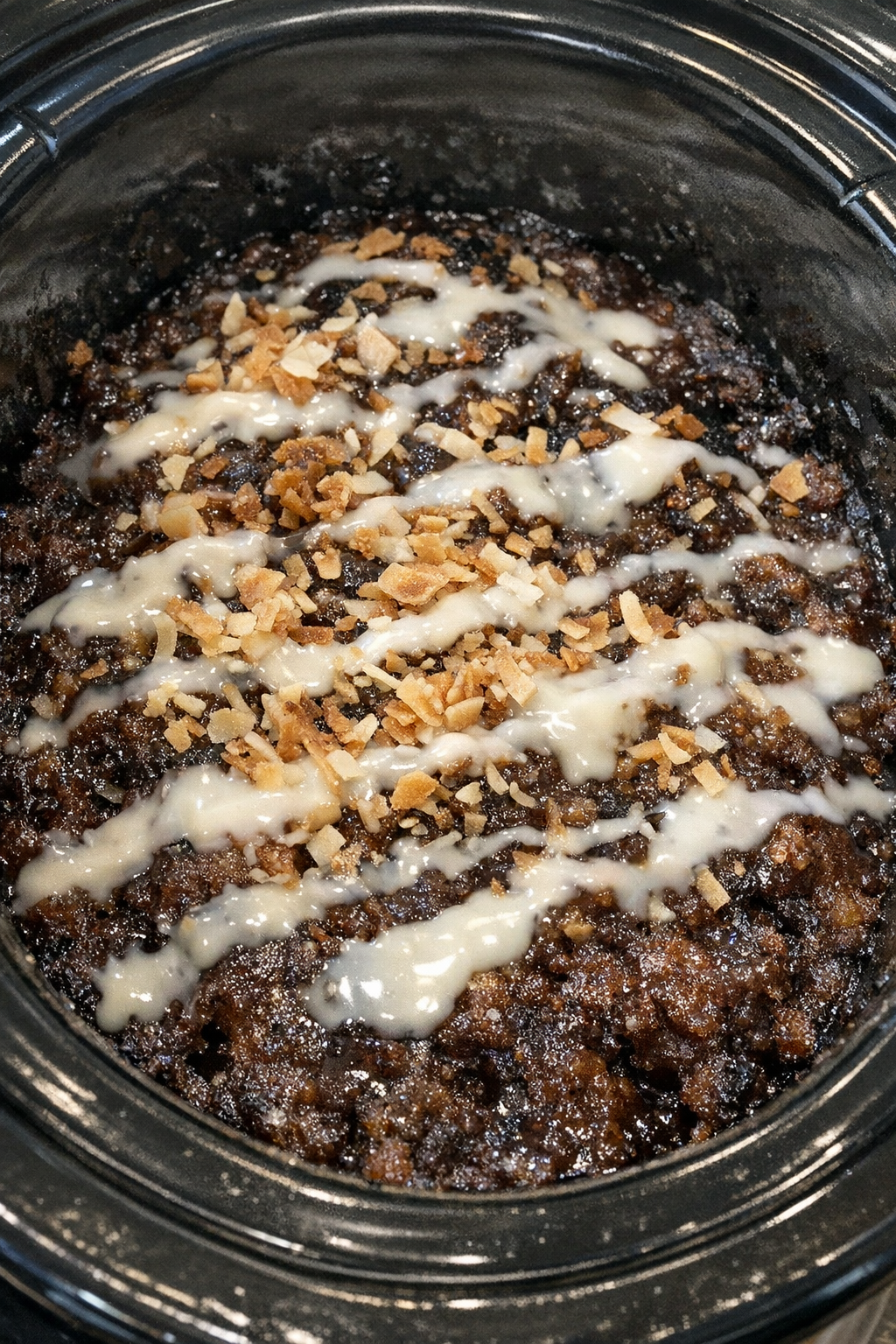Slow cooker dirty soda dump cake in a black slow cooker