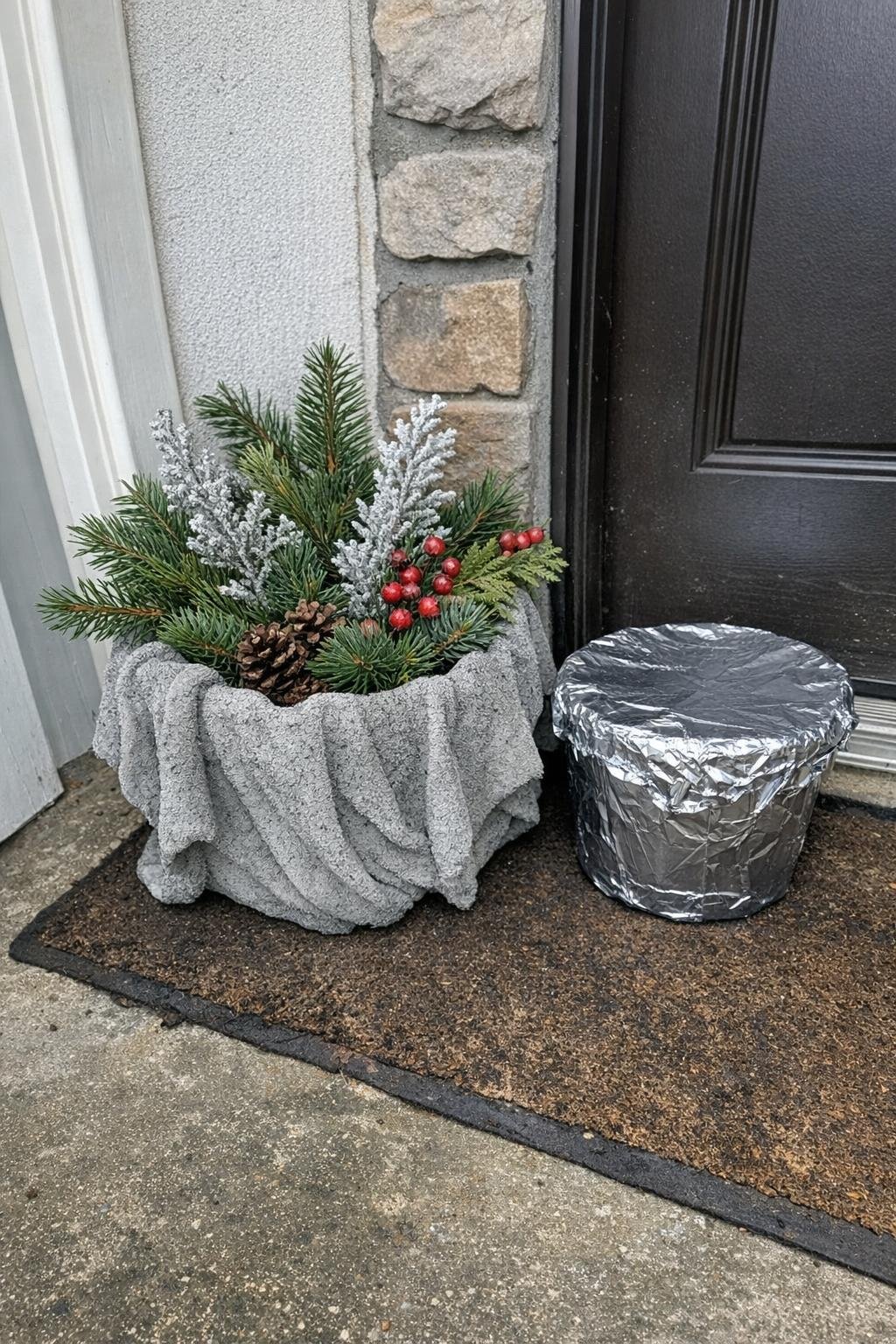 Draped concrete towel planter holding winter greenery