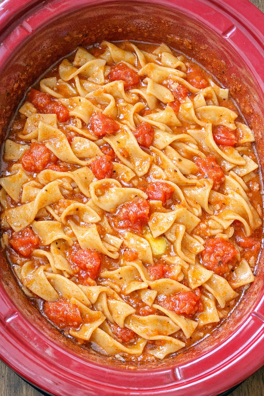 Slow cooker Amish tomato gravy noodles in a red slow cooker