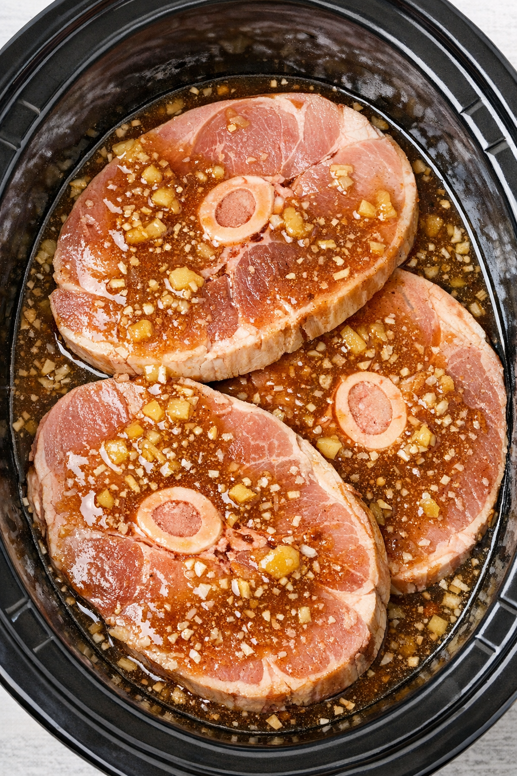Ham steaks covered with sauce in slow cooker