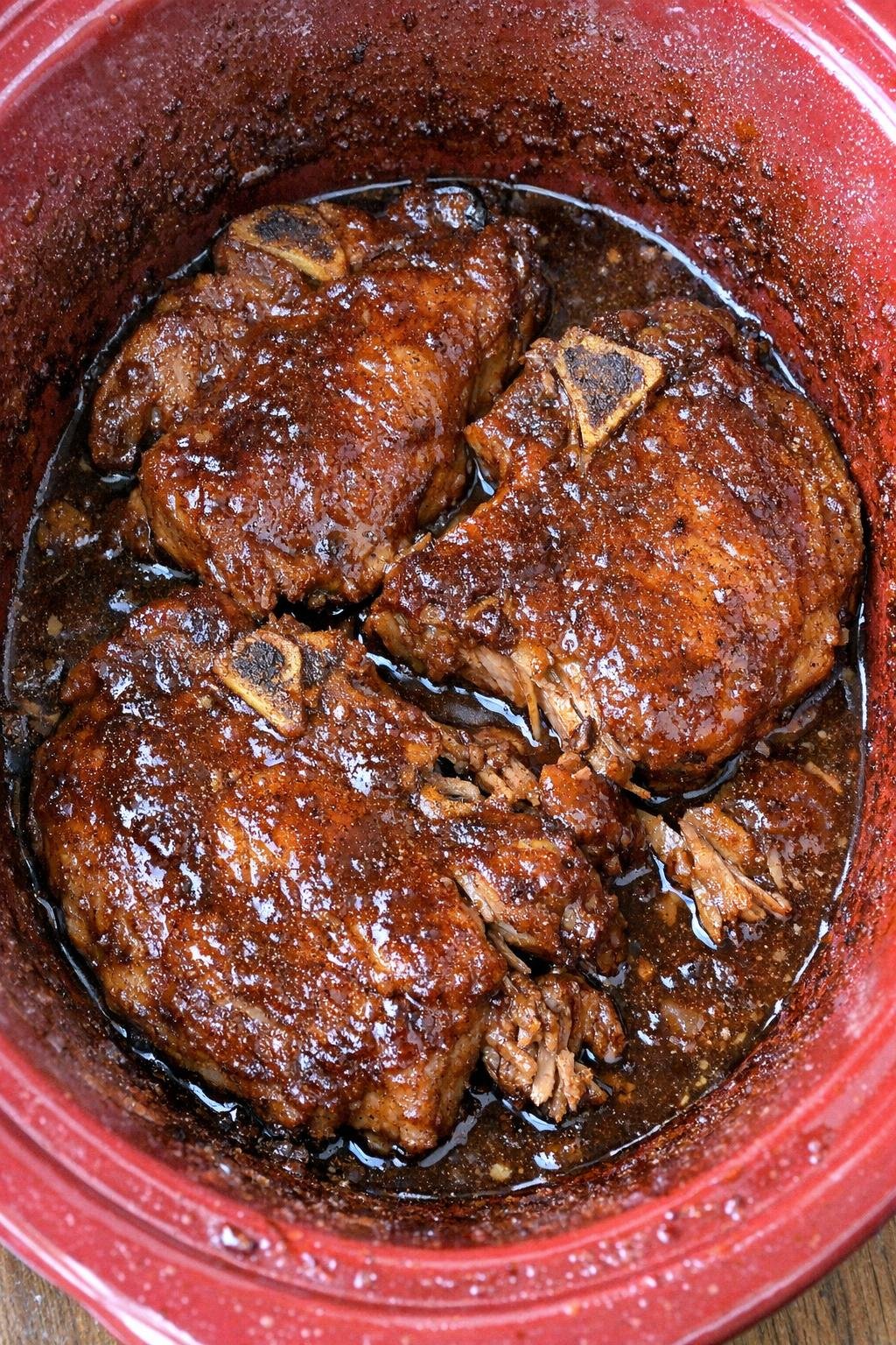 Slow cooker apple butter pork chops in a red slow cooker