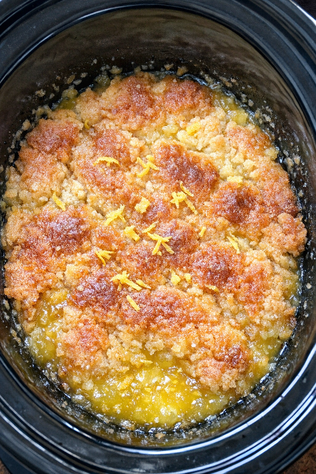 Finished limoncello spritz dump cake in a black slow cooker