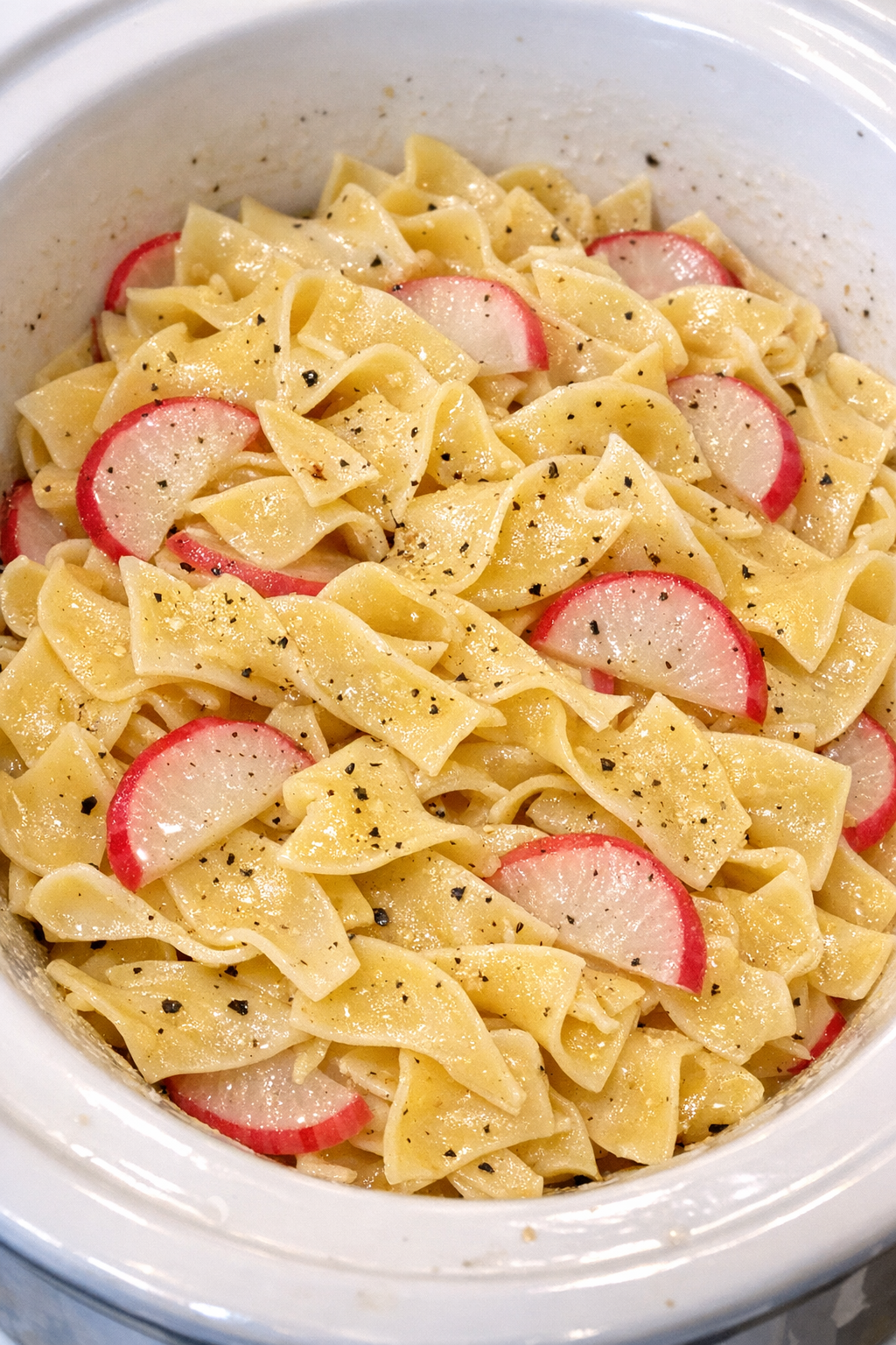 Slow cooker Amish radish butter noodles in a white slow cooker