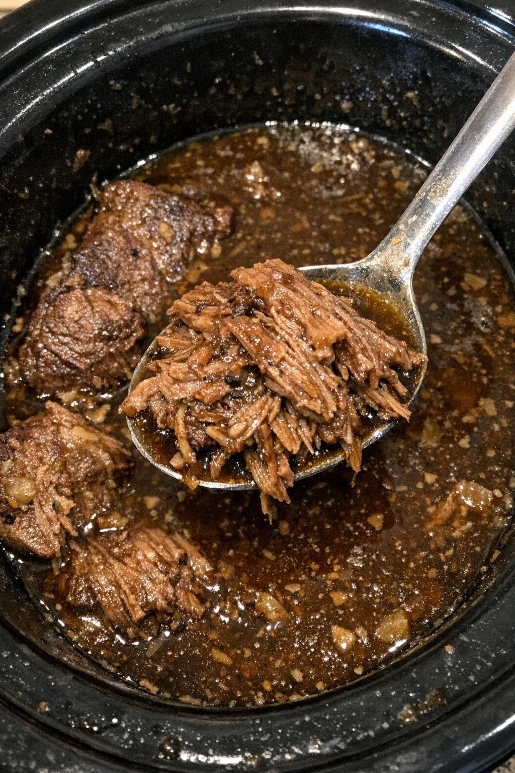 Tender beef roast in rich gravy in a slow cooker