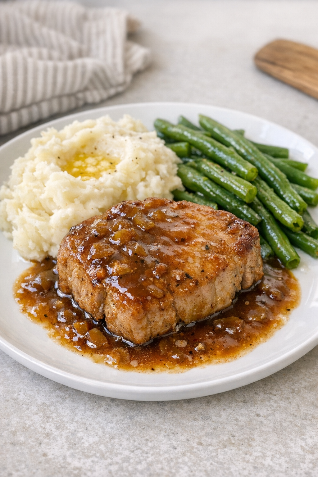 Finished slow cooker pork chops plated with sauce