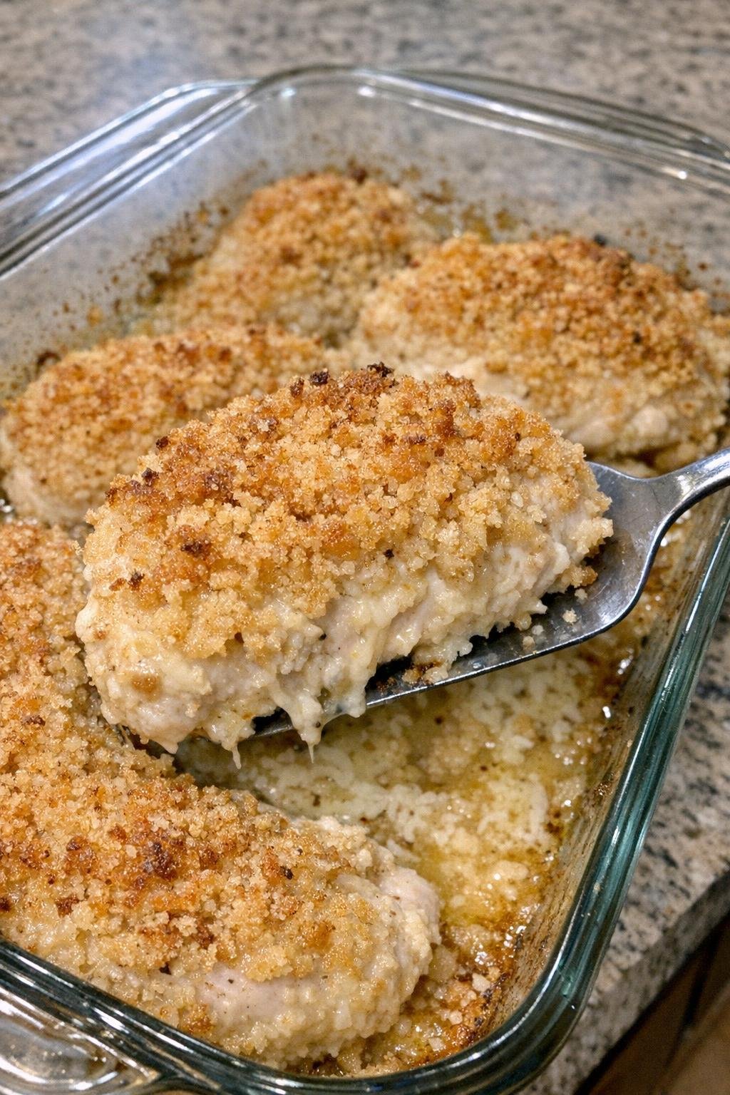 Elegant chicken breasts with golden crumb crust in a glass baking dish