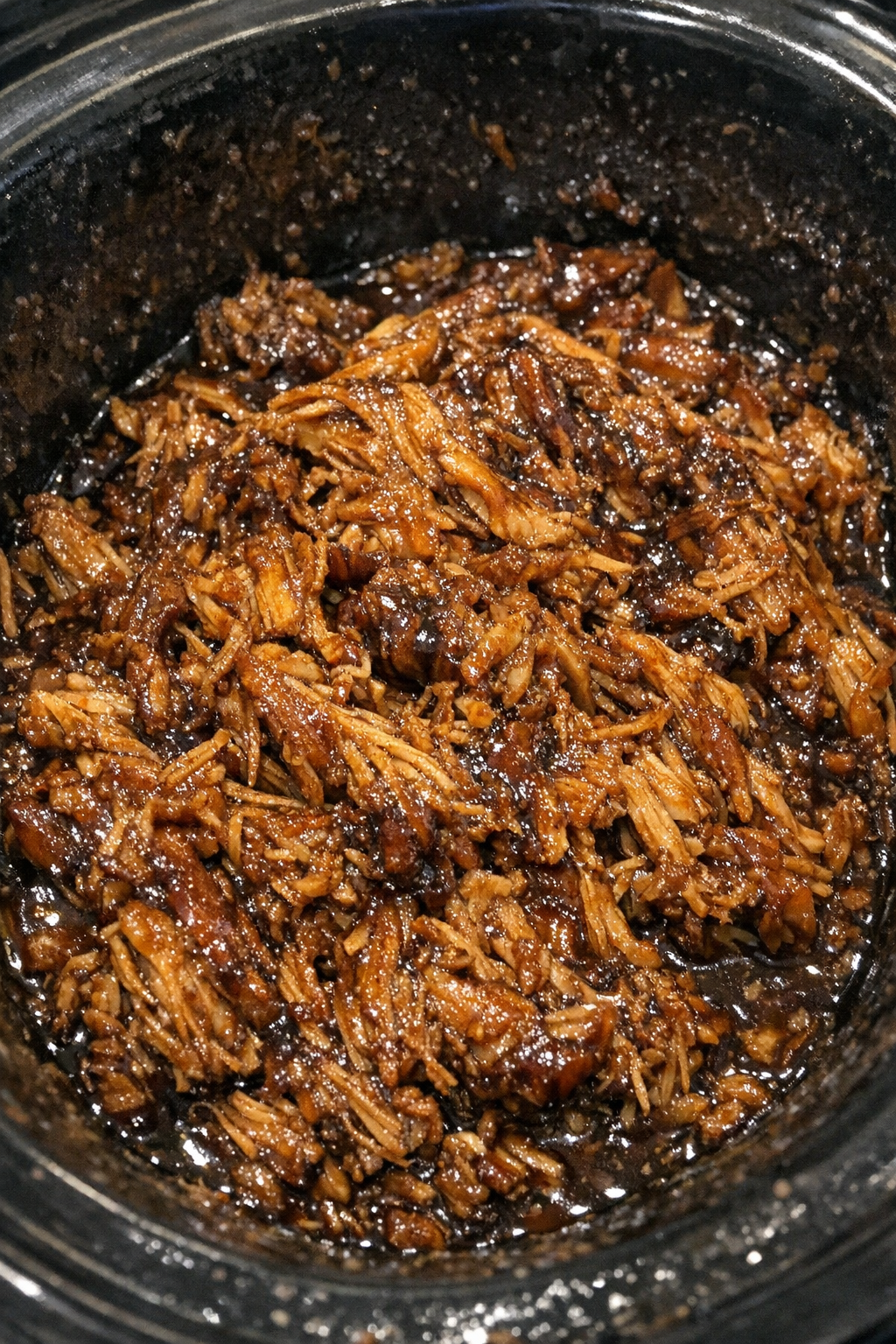 Shredded glazed protein in a slow cooker
