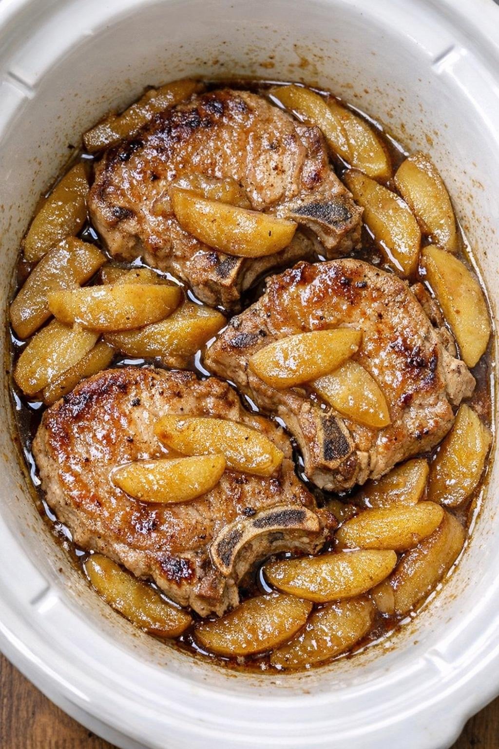 Slow cooker maple apple pork chops in a white slow cooker