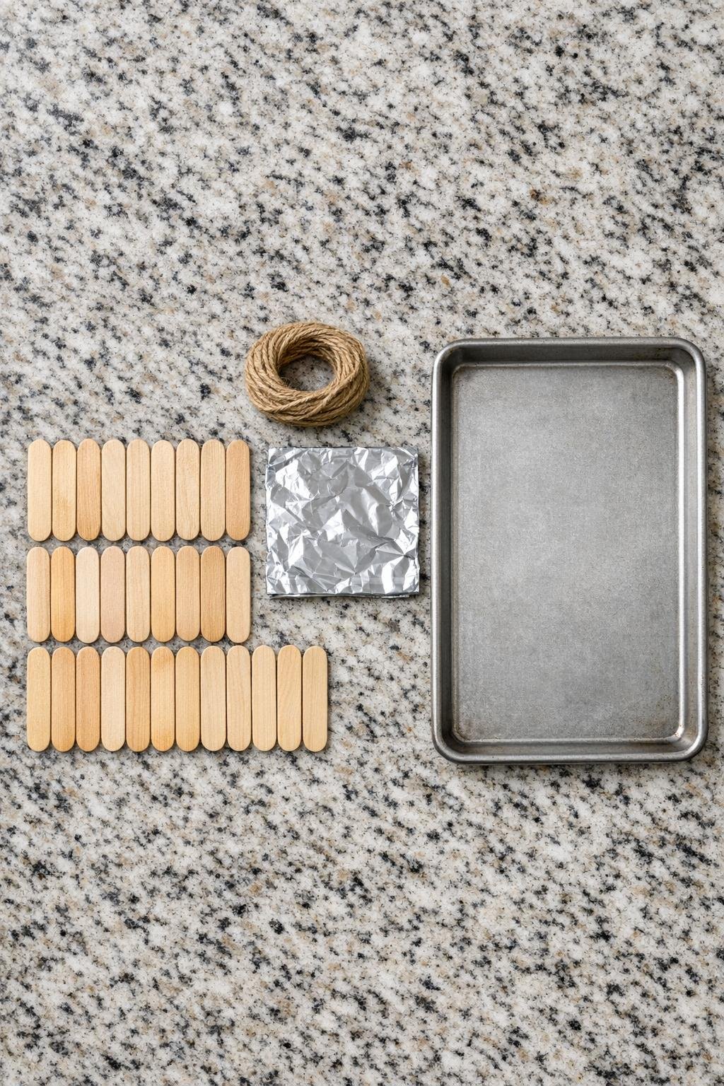 Baked popsicle sticks and twine laid out for the project