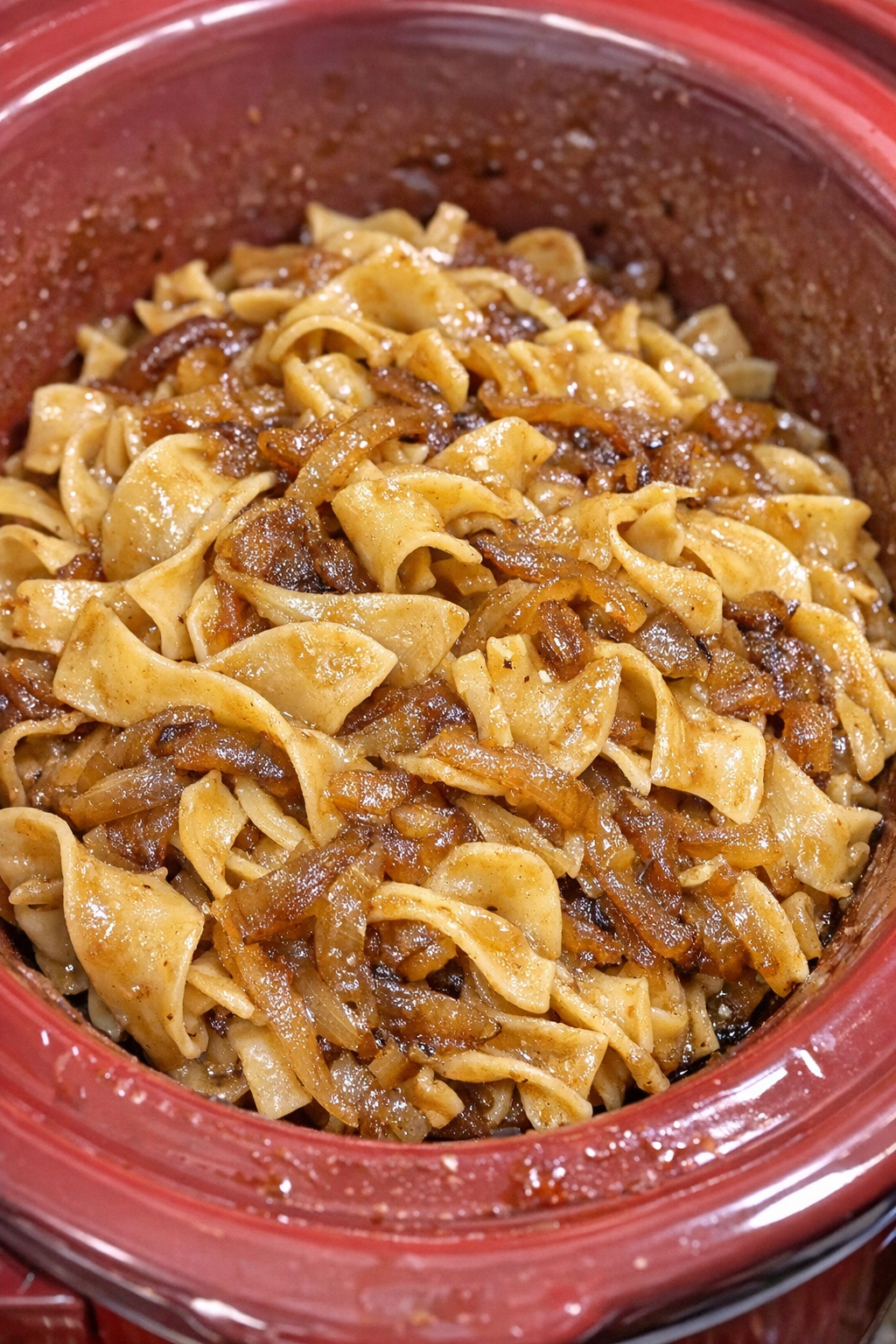 Slow cooker Amish sweet onion noodles in a red slow cooker