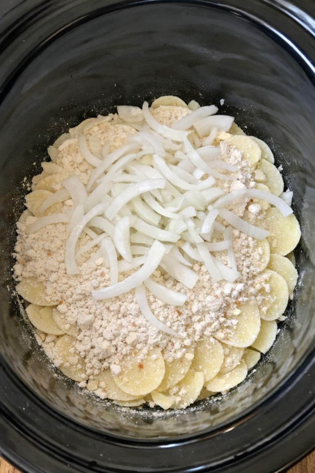 Dry potatoes and onions layered in a slow cooker