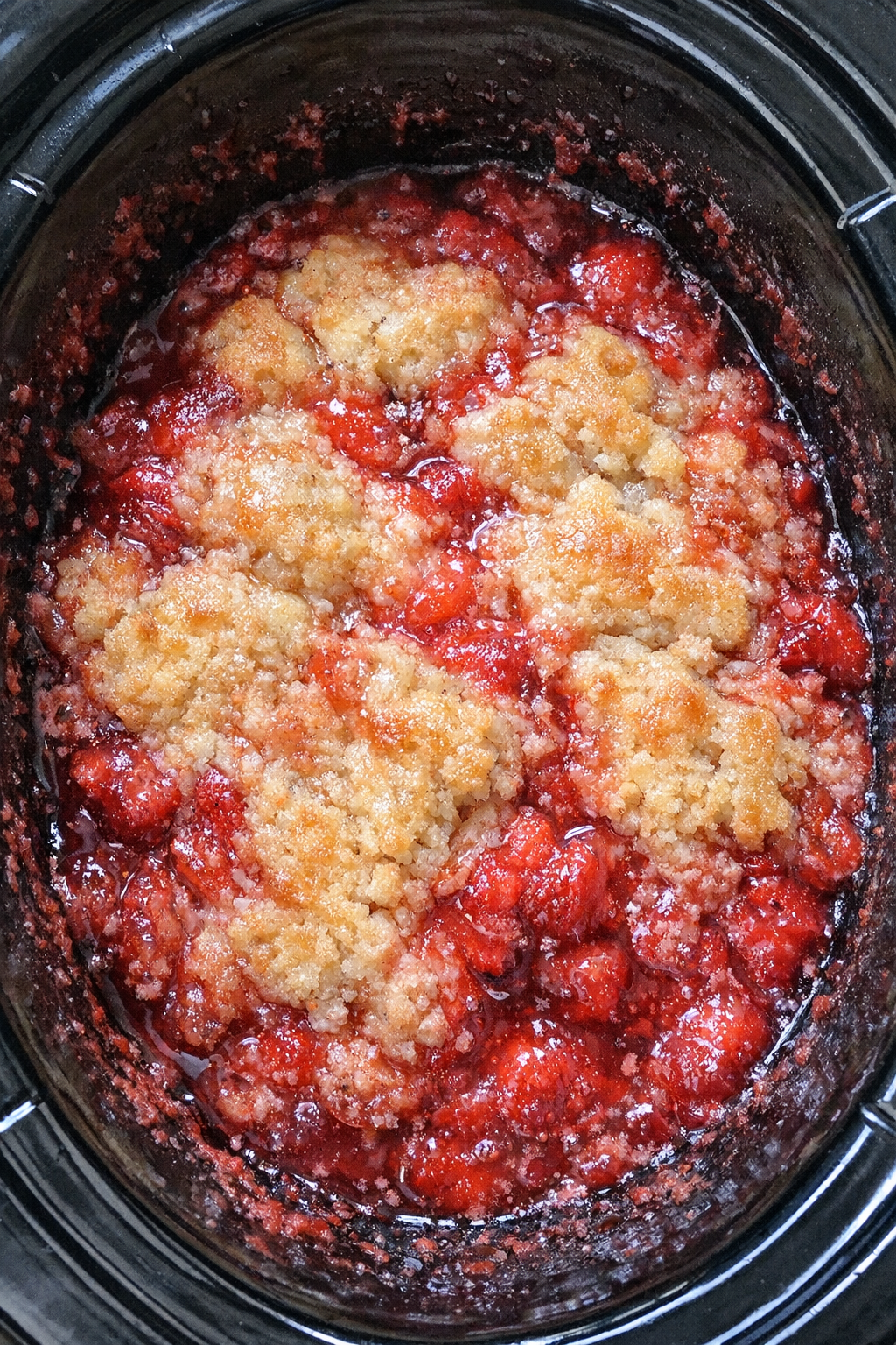 Slow cooker strawberry daiquiri cobbler in a black slow cooker