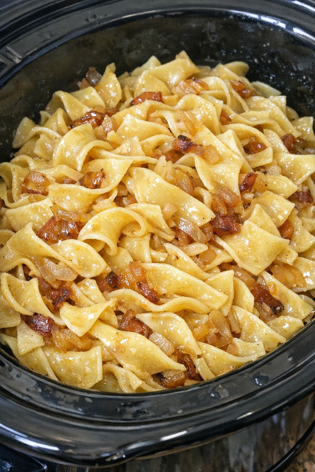 Slow cooker Amish onion butter noodles in a black slow cooker