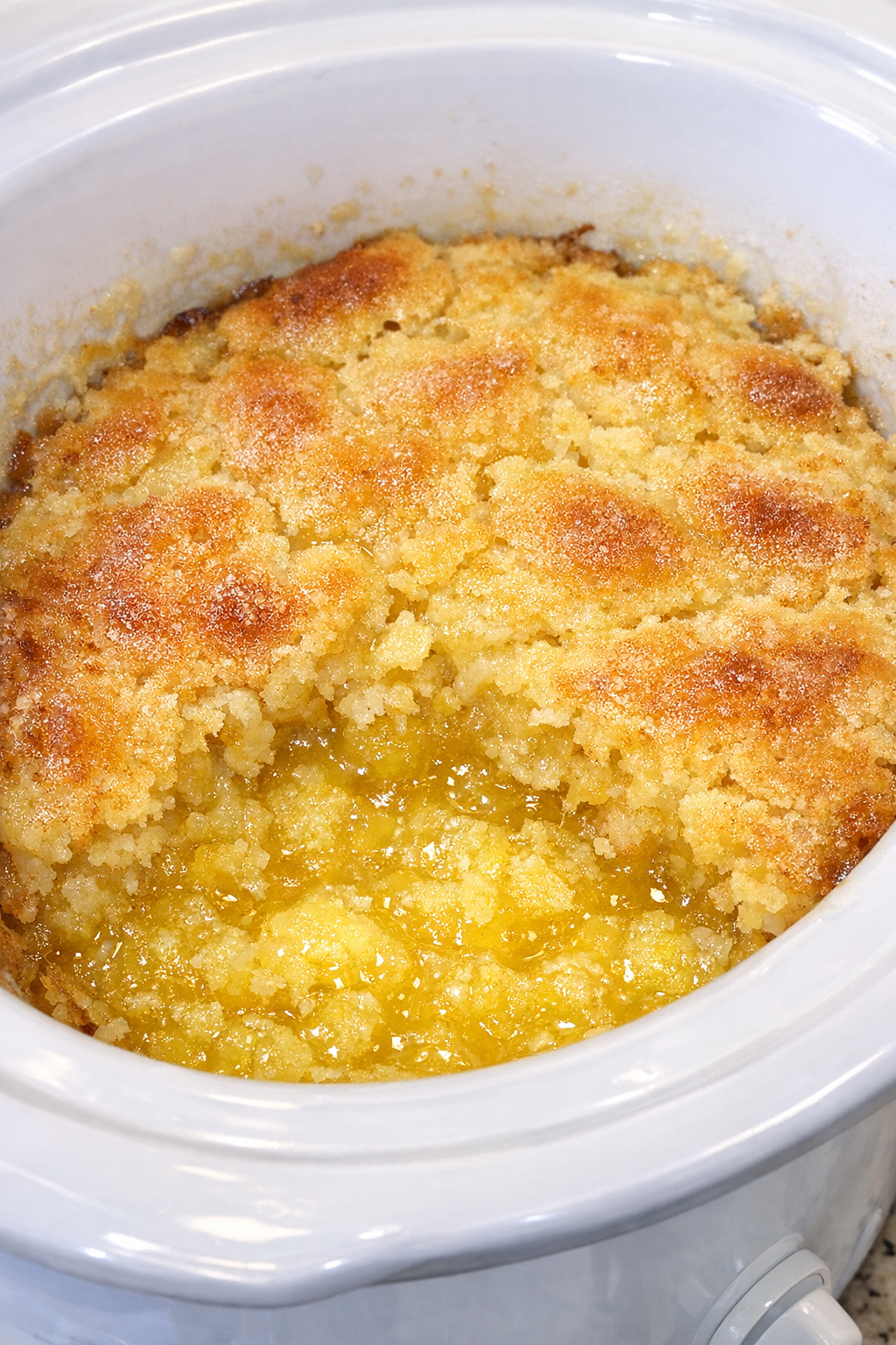 Slow cooker limoncello spritz dump cake in a white slow cooker