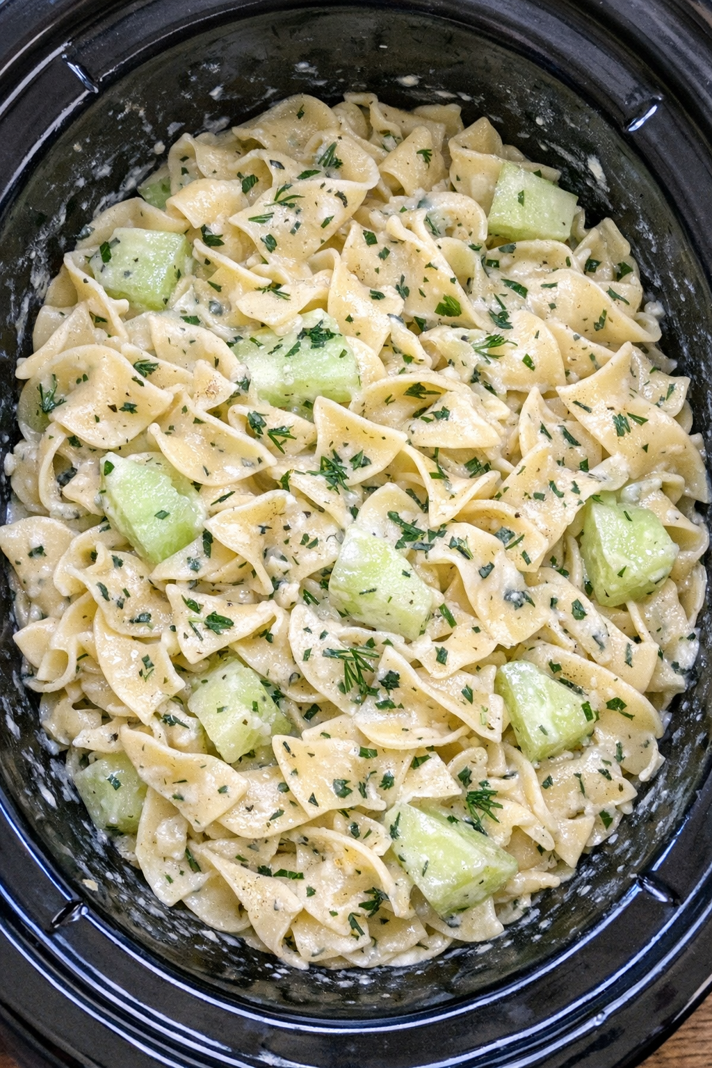 Slow cooker Amish cucumber cream noodles in a black slow cooker