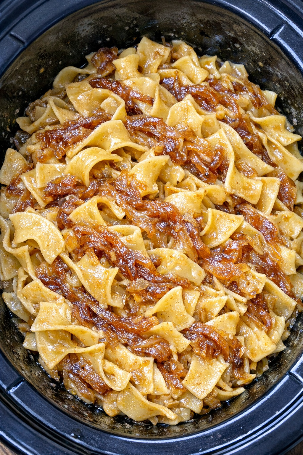 Slow cooker Amish caramelized onion noodles in a black slow cooker