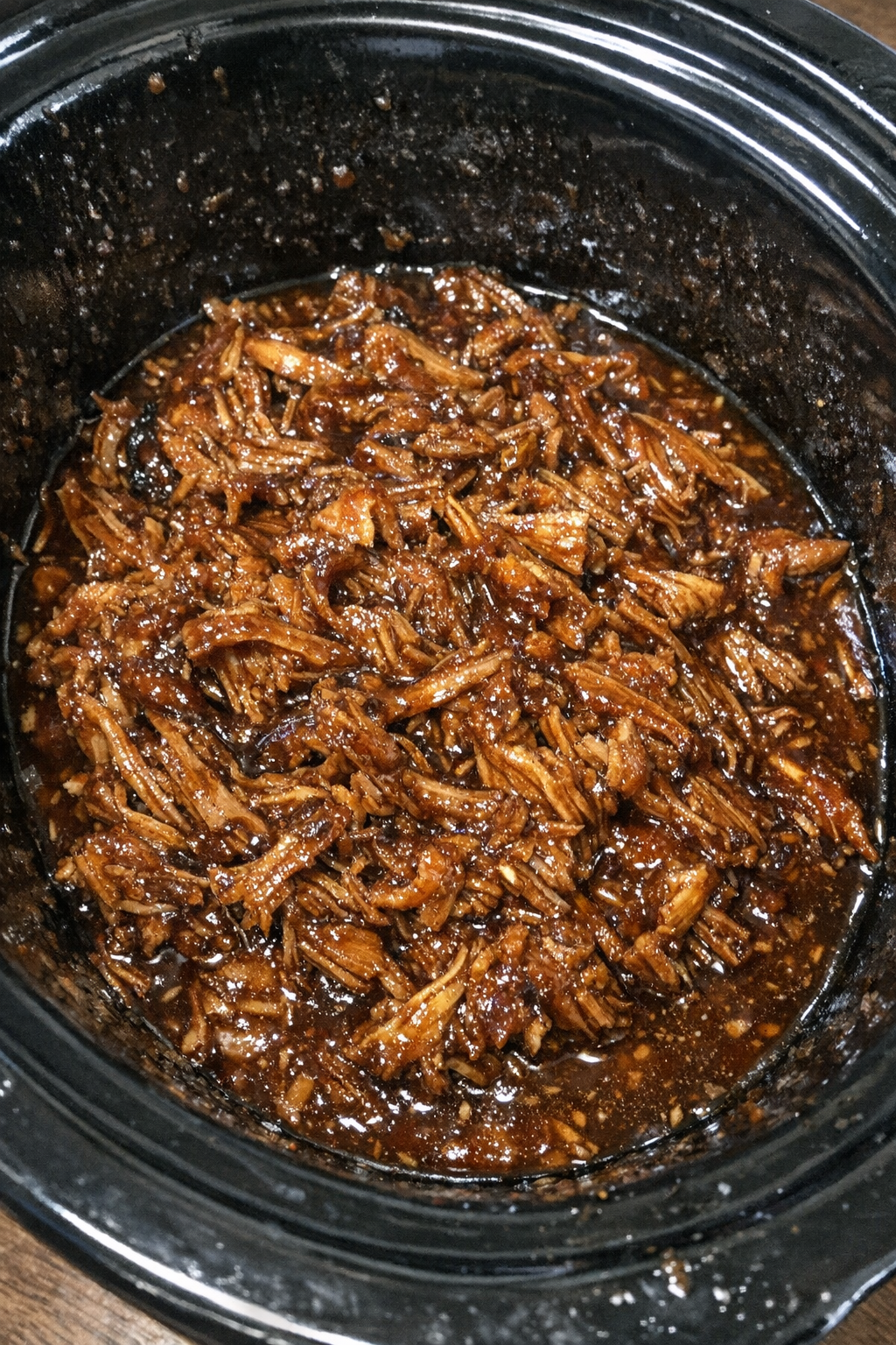 Succulent shredded protein glazed with amber sauce in a slow cooker