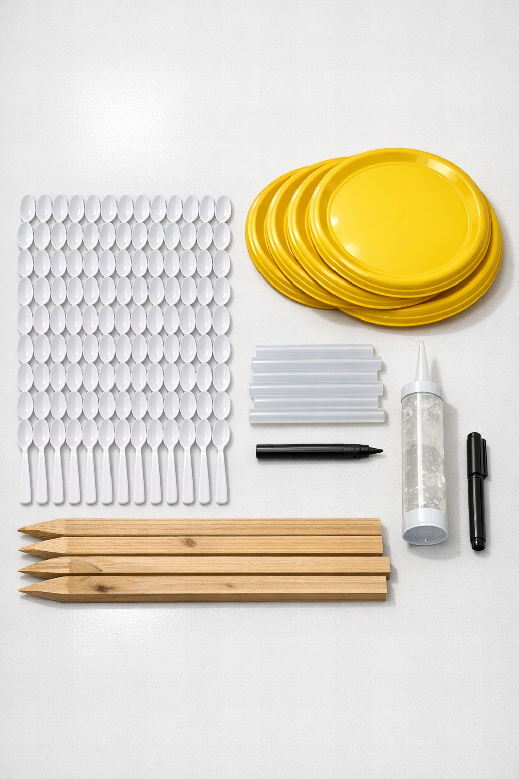 Materials laid out for giant plastic spoon and frisbee daisies