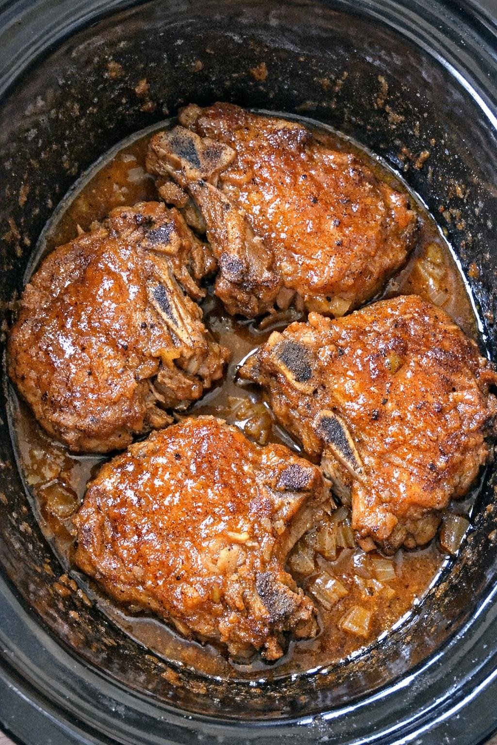 Slow cooker pumpkin spice pork chops in a black slow cooker