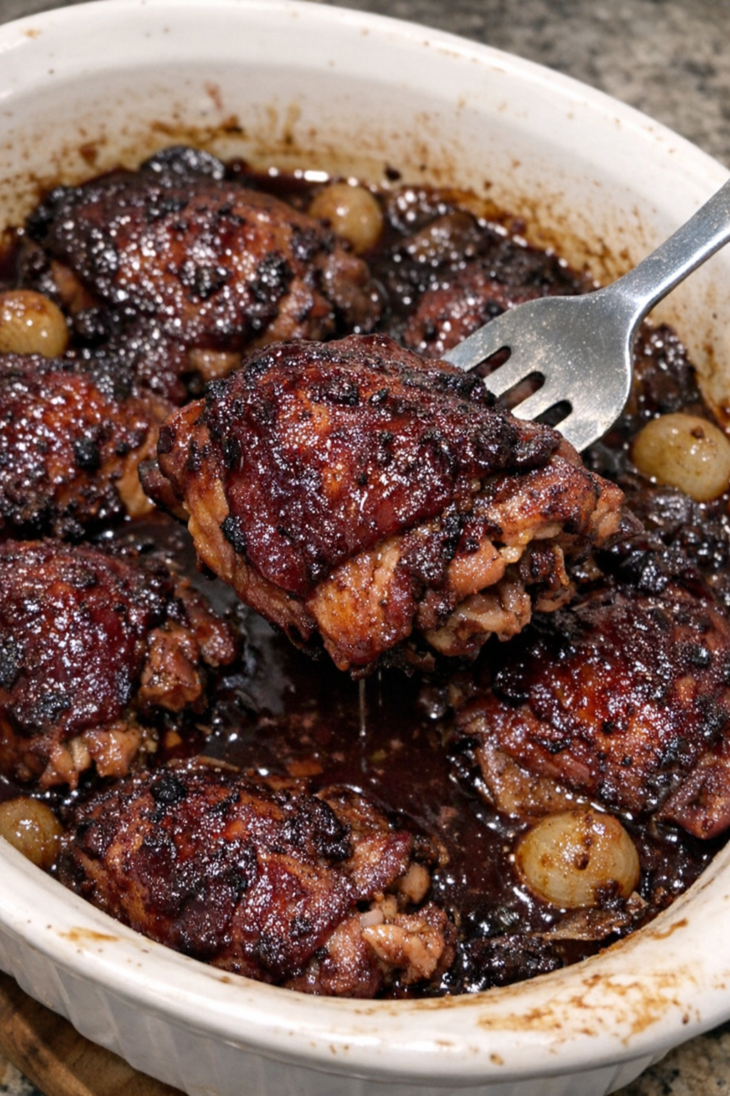 Wine-braised chicken with burgundy glaze in a white casserole dish